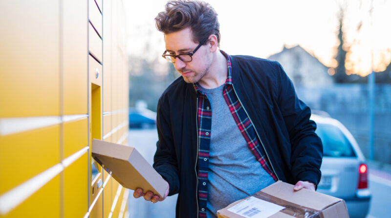 mann holt paket aus packstation